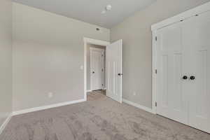 Unfurnished bedroom featuring carpet floors and baseboards