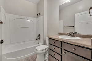 Bathroom with bathing tub / shower combination, vanity, and light wood finished floors