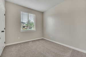 Empty room with light carpet and baseboards