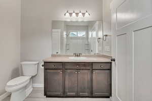 Bathroom featuring vanity, tiled shower, and light wood-style flooring
