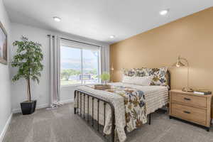 Carpeted bedroom with a mountain view and recessed lighting