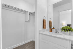 Bathroom featuring vanity and a spacious closet
