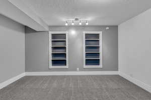 Unfurnished room with carpet flooring and a textured ceiling