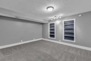 Empty room featuring carpet floors and a textured ceiling