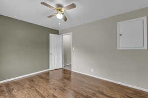 Unfurnished room featuring dark wood finished floors and a ceiling fan