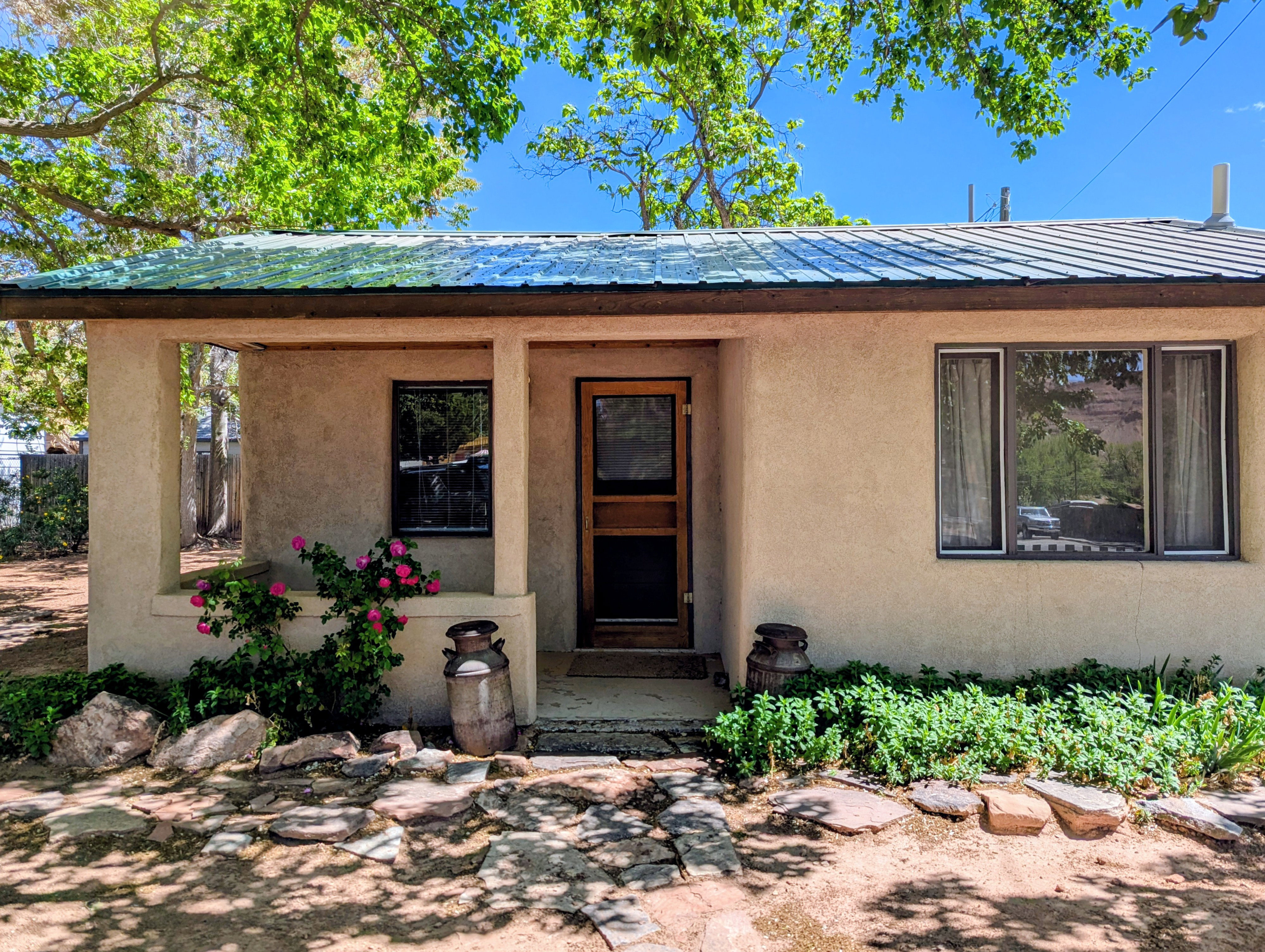 Entrance to property with a metal roof and stucco siding