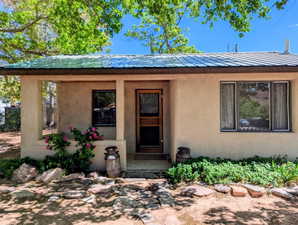 Entrance to property with a metal roof and stucco siding