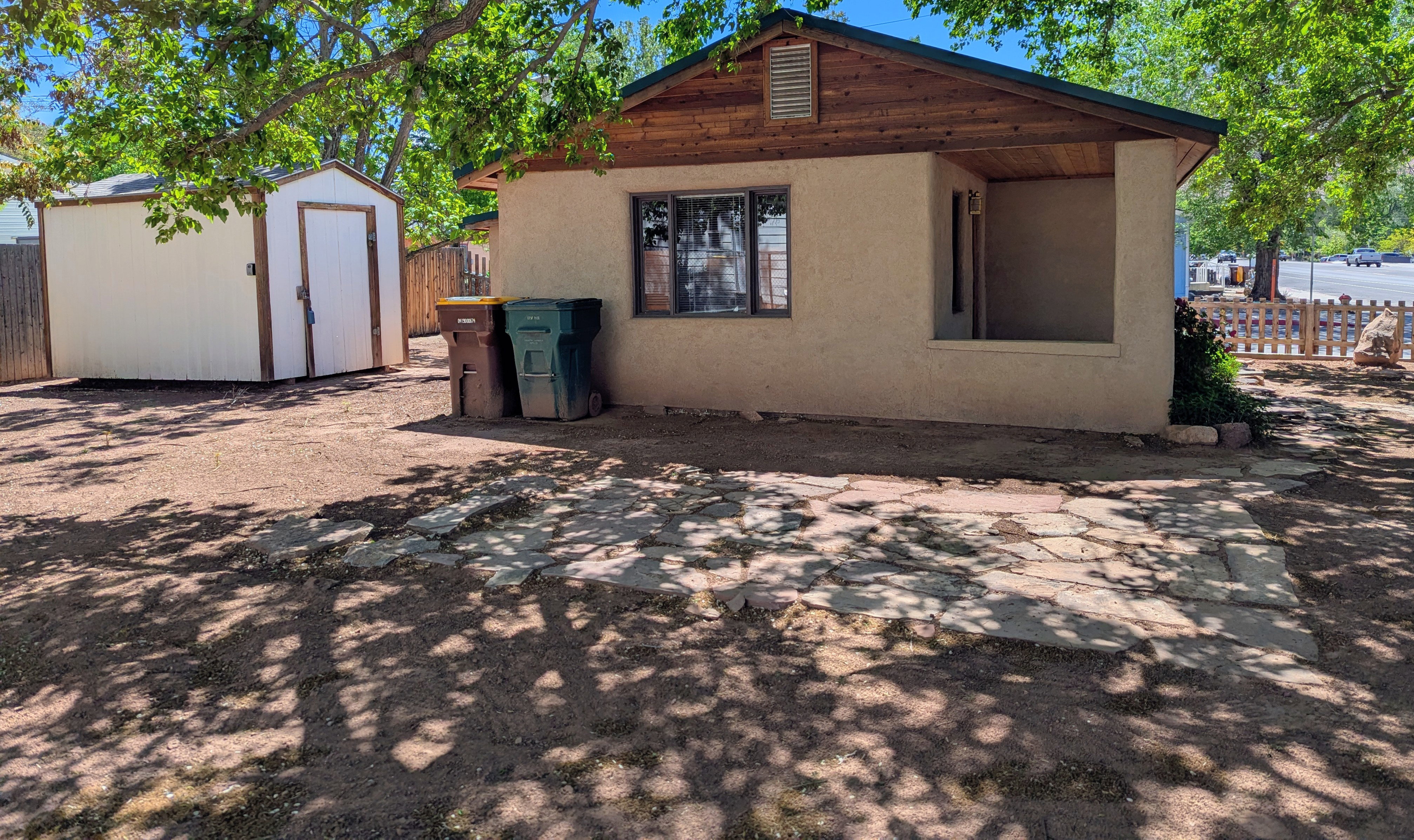 Back of property with stucco siding and a storage shed