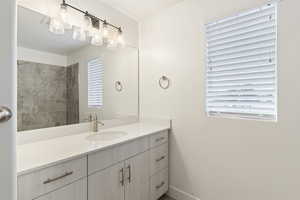 Full bath featuring vanity and baseboards