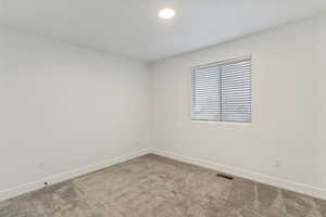 Carpeted empty room with baseboards and recessed lighting