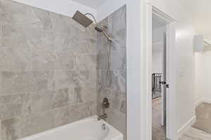 Full bathroom featuring shower / tub combination and baseboards