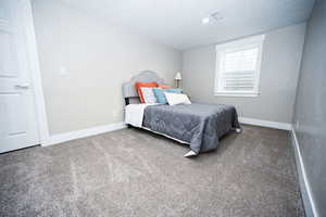 Carpeted bedroom featuring a textured ceiling
