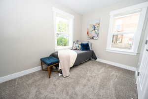 Bedroom featuring light colored carpet and baseboards