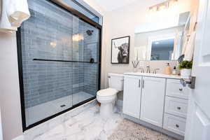 Bathroom featuring vanity, a shower stall, and light marble finish flooring