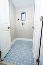 Laundry room featuring hookup for a washing machine, light tile patterned flooring, and hookup for an electric dryer