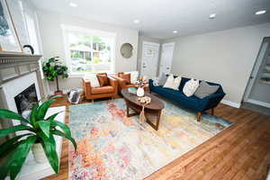Living area with recessed lighting, wood finished floors, and a fireplace with flush hearth