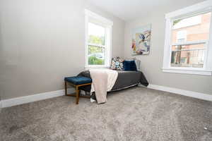Bedroom with baseboards and light colored carpet