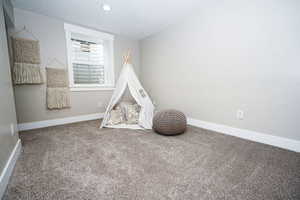 Rec room featuring carpet and a textured ceiling