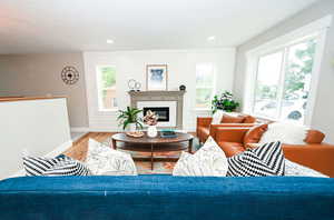 Living room featuring wood finished floors, a high end fireplace, and recessed lighting