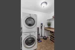 Washroom featuring estacked washer and dryer and light tile patterned floors