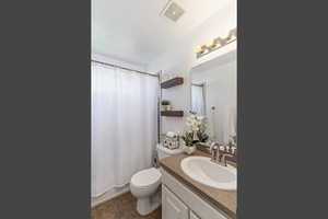 Full bath with vanity, shower / bath combination with curtain, and dark tile patterned flooring