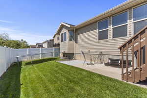 Rear view of property with a patio and a fenced backyard