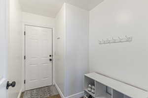 Mudroom featuring baseboards and dark tile patterned flooring