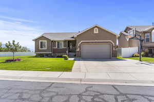 View of front of property with concrete driveway, an attached garage, and stucco siding