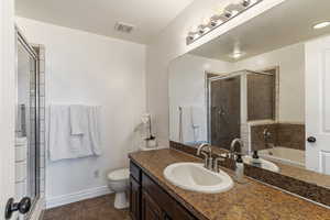 Bathroom featuring vanity, a shower stall, dark tile patterned floors, and a garden tub