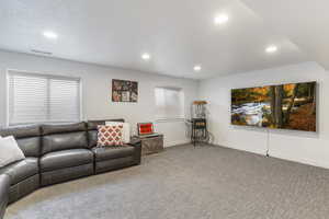 Carpeted living area with baseboards and recessed lighting