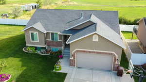 View of front facade with brick siding, roof with shingles, stucco siding, driveway, and a garage