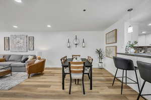 Dining space with recessed lighting and light wood-style flooring