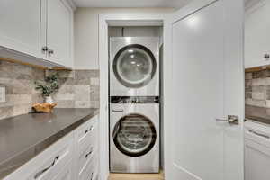 Washroom featuring stacked washer / drying machine