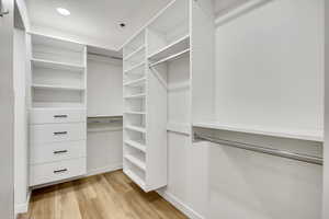 Walk in closet with light wood-style floors