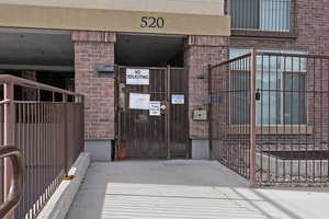 Entrance to property featuring a gate and brick siding