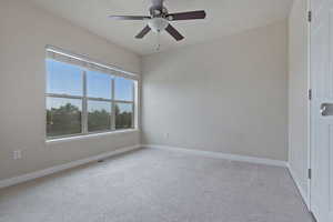 Spare room featuring light colored carpet, ceiling fan, and a textured ceiling