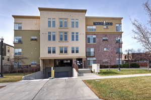 View of apartment building / complex featuring an attached garage and concrete driveway