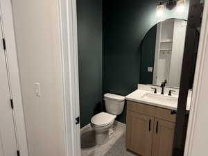 Half bathroom featuring vanity and light tile patterned floors