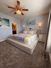 Bedroom featuring carpet floors, ceiling fan, and ensuite bath