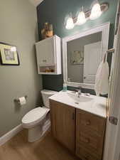 Half bath featuring wood finished floors and vanity