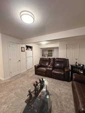 Carpeted living area featuring baseboards