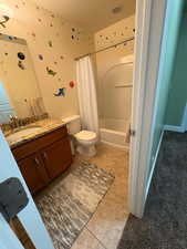 Full bathroom featuring vanity, light tile patterned flooring, and shower / bathtub combination with curtain