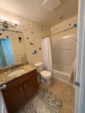 Bathroom featuring shower / bath combo, vanity, and light tile patterned floors