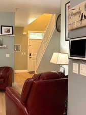 Living room with light wood-style flooring and stairs