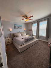 Carpeted bedroom featuring a ceiling fan and baseboards