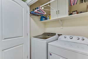 Laundry area featuring independent washer and dryer and cabinet space