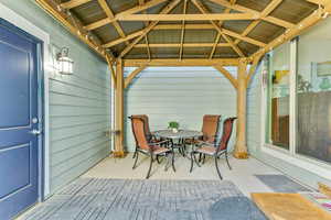 View of patio with outdoor dining area and a gazebo