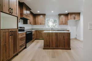 Kitchen featuring stainless steel range with electric cooktop, a kitchen island, light stone countertops, light wood-style flooring, and recessed lighting