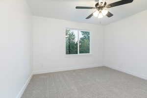 Spare room featuring light carpet and ceiling fan