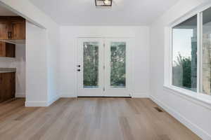 Doorway with wood finished floors and baseboards